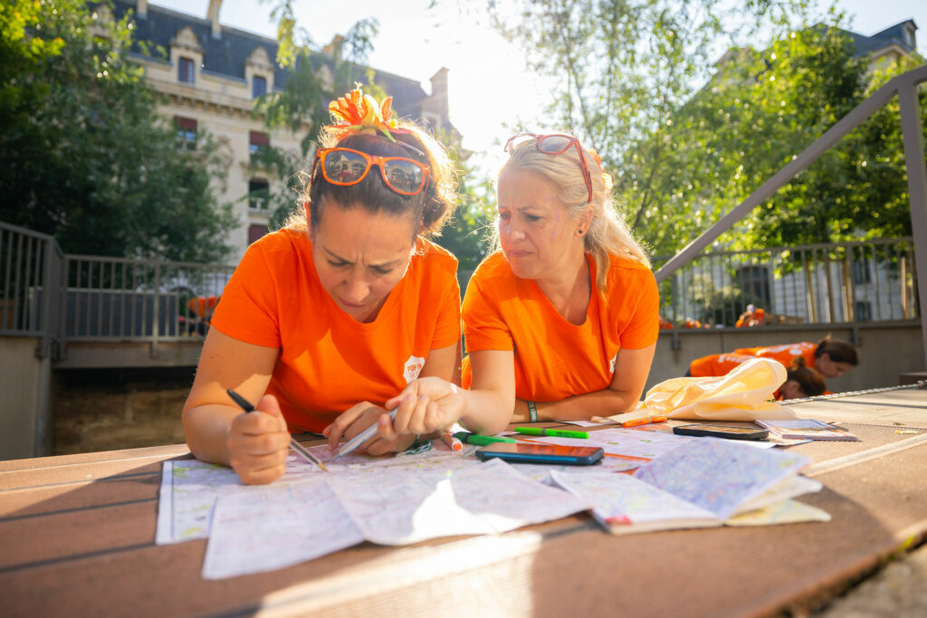 Femmes penchées sur la carte de Lyon lors d'une visite de la ville entre copines