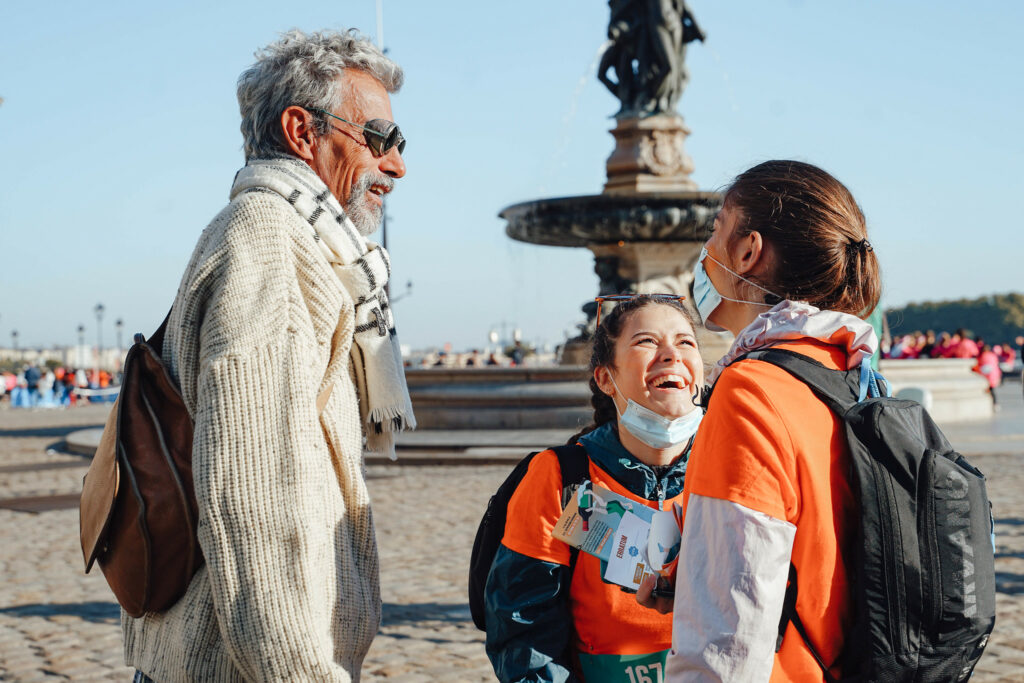 Femmes qui participent à une visite guidée insolite de Bordeaux et qui rient avec leur guide