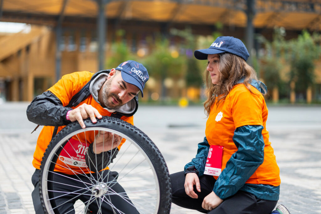 Homme et femmes qui réparent ensemble un vélo lors d'un team building original