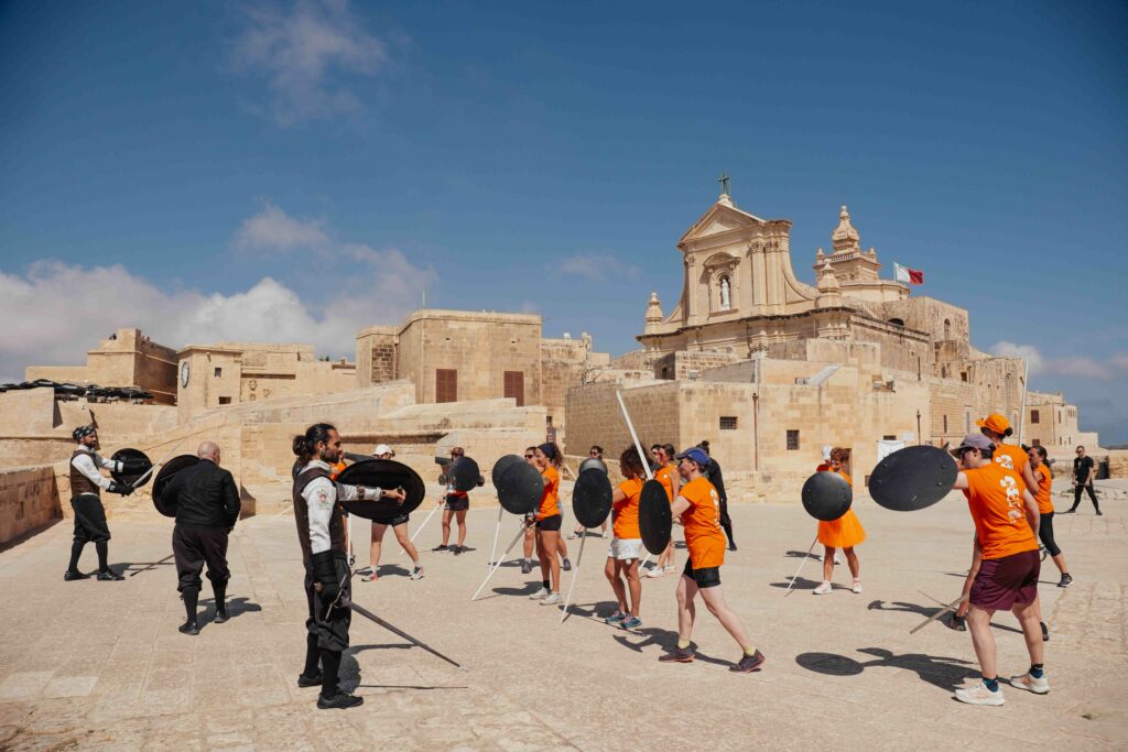 Femmes qui participent à un combat d'escrime historique lors de leur visite de la Citadelle de Victoria à Gozo