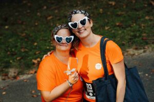 Filles avec des lunettes en forme de coeur et un t-shirt orange lors d'un week-end entre filles en Europe