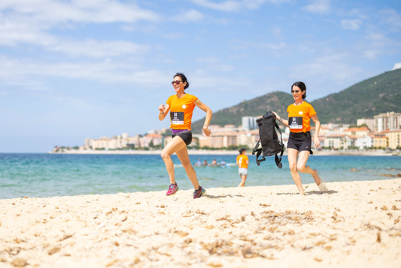 Femmes en t-shirt orange qui courent sur une plage à Ajaccio lors de leur visite de la ville entre copines