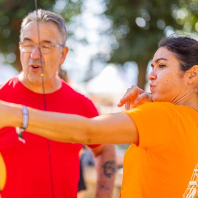 Popeuse qui apprend à tirer à l'arc lors d'un team building